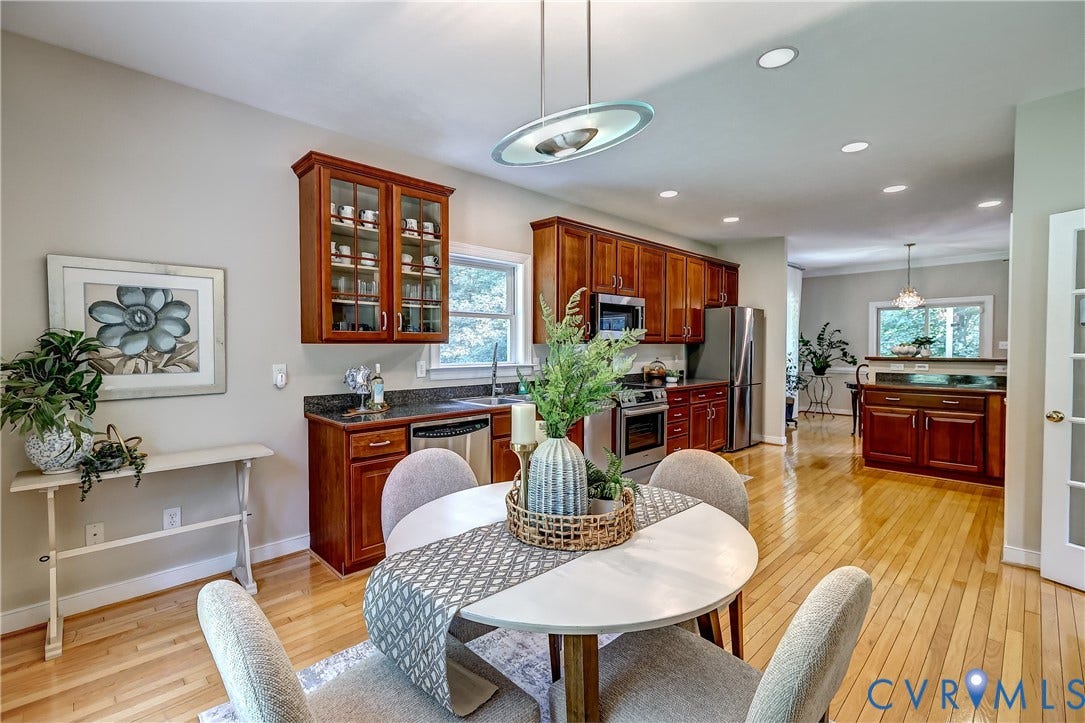 Hardwood flooring throughout, stainless steel appliances, recessed lighting, and rich wood-finish cabinetry