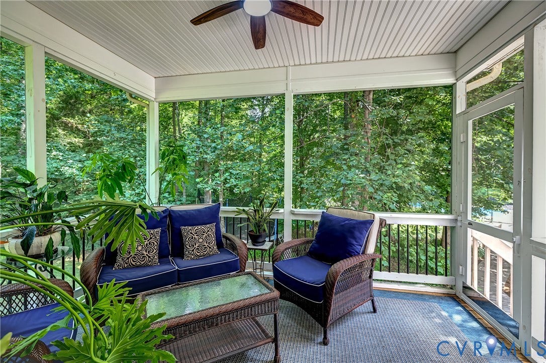 Screened porch with a ceiling fan, white paneled ceiling, and black railings