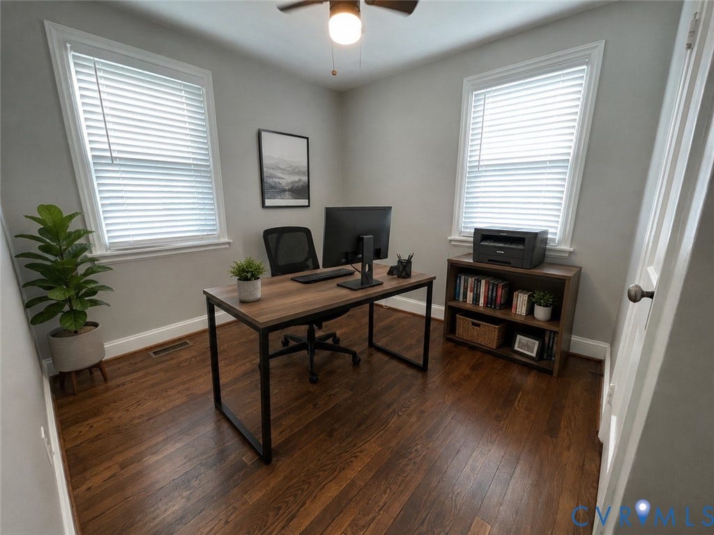 Hardwood flooring, two windows with blinds, ceiling fan, and light gray wall paint