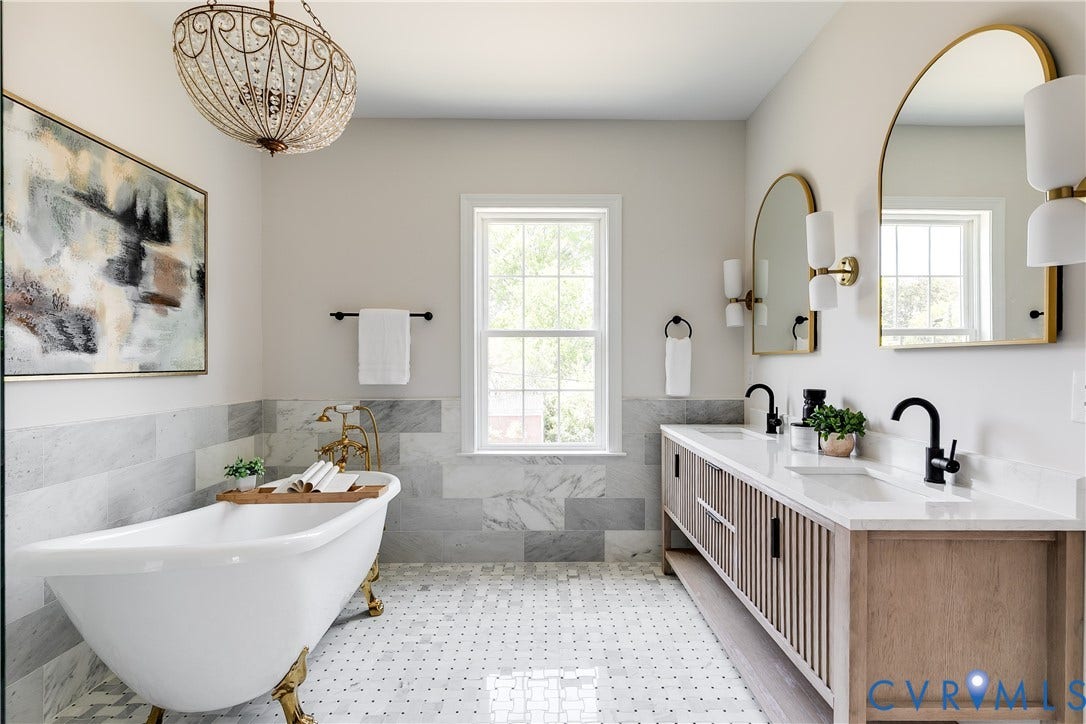 404 W 31st Street, Woodland Heights, Richmond, VA 23225 Freestanding clawfoot tub with brass fixtures, dual vanity with wood-finish cabinetry, white countertop, and black faucets, arched mirrors, and mosaic tile flooring