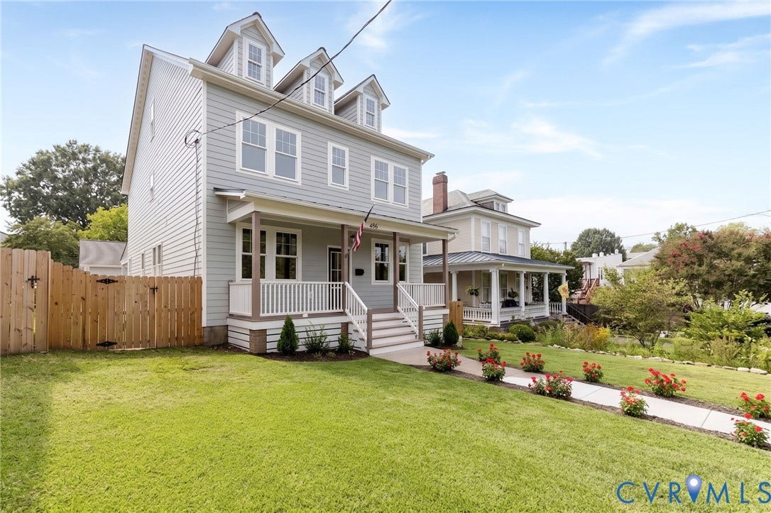 404 W 31st Street, Woodland Heights, Richmond, VA 23225 Light gray siding exterior with multiple dormer windows, a full-width front porch, and a white picket fence