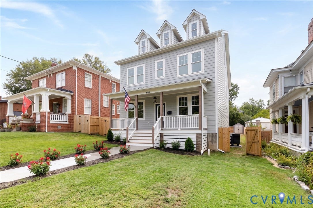 404 W 31st Street, Woodland Heights, Richmond, VA 23225 Two-story residence featuring dormer windows, a covered front porch, and a level lawn with a paved walkway
