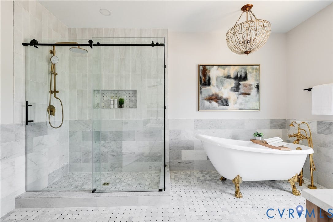 404 W 31st Street, Woodland Heights, Richmond, VA 23225 Glass-enclosed walk-in shower with gold-tone fixtures, freestanding clawfoot tub, white and gray tiled flooring, and a decorative chandelier