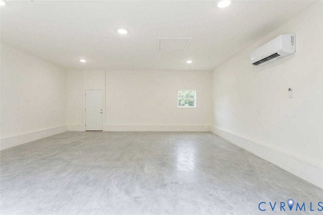 404 W 31st Street, Woodland Heights, Richmond, VA 23225 Spacious room featuring a concrete floor, white walls, recessed ceiling lights, and a wall-mounted mini-split unit