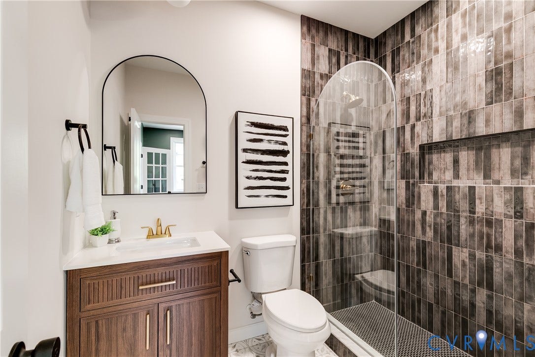 404 W 31st Street, Woodland Heights, Richmond, VA 23225 Contemporary bathroom featuring a dark wood-finish vanity with gold-tone hardware, white countertop, and integrated sink