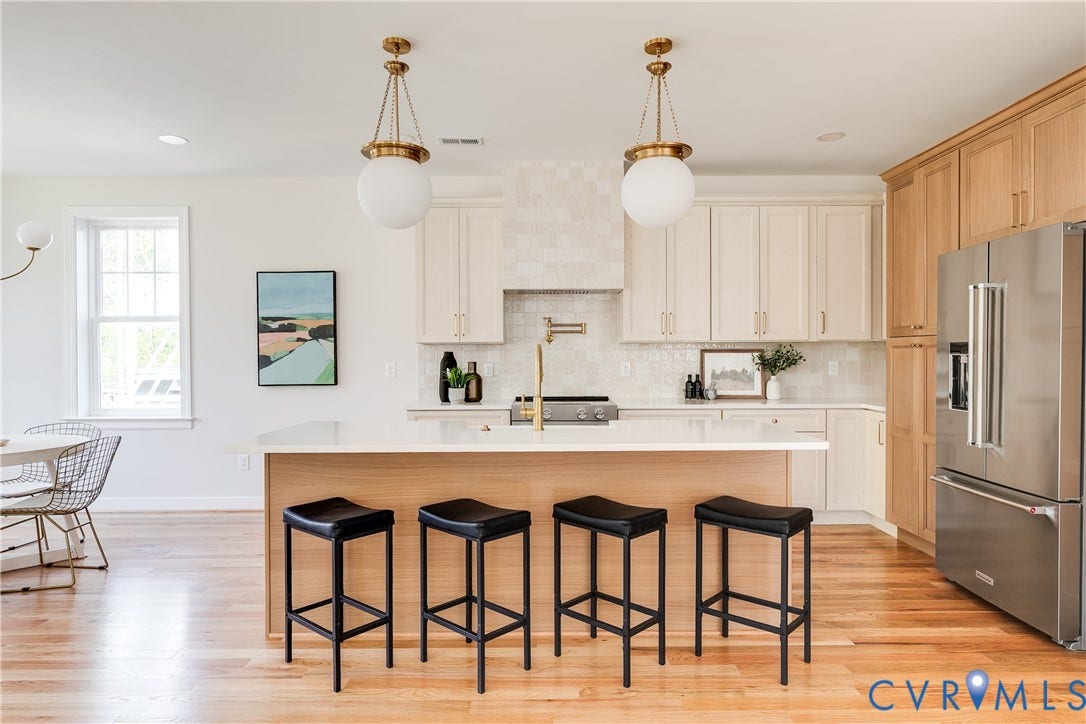 404 W 31st Street, Woodland Heights, Richmond, VA 23225 Kitchen featuring an island with seating, stainless steel refrigerator, light-toned wood-finish cabinetry, white countertops, and wood-finish flooring
