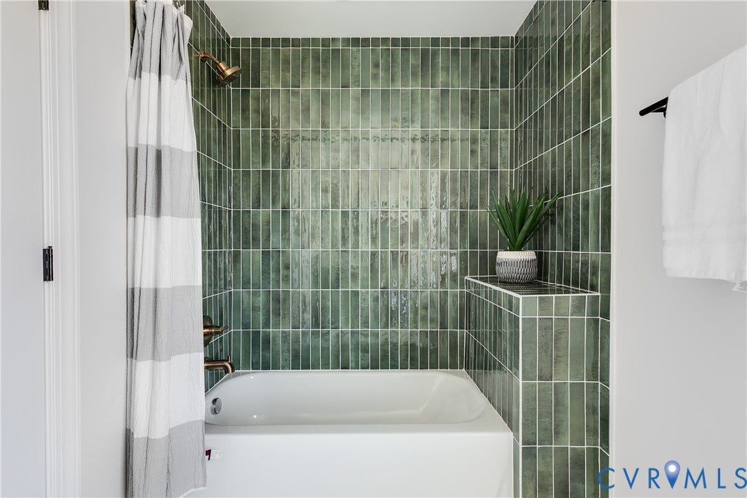 404 W 31st Street, Woodland Heights, Richmond, VA 23225 Shower and tub combination featuring vertical green tile, built-in tiled shelf, and bronze-finish fixtures