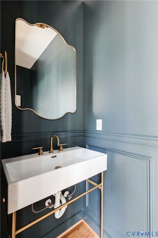 404 W 31st Street, Woodland Heights, Richmond, VA 23225 White console sink with brass-finish legs, brass-finish faucet, and a brass-finish framed mirror