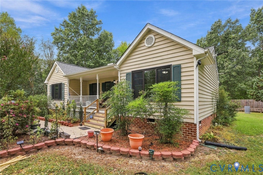 133 Ford Road, Bumpass, VA 23024 Exterior featuring light-colored siding, dark window shutters, a covered porch with white railings, and a brick foundation