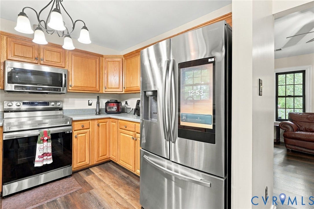 133 Ford Road, Bumpass, VA 23024 Kitchen featuring wood cabinetry, stainless steel appliances, a corner sink, and wood-finish flooring