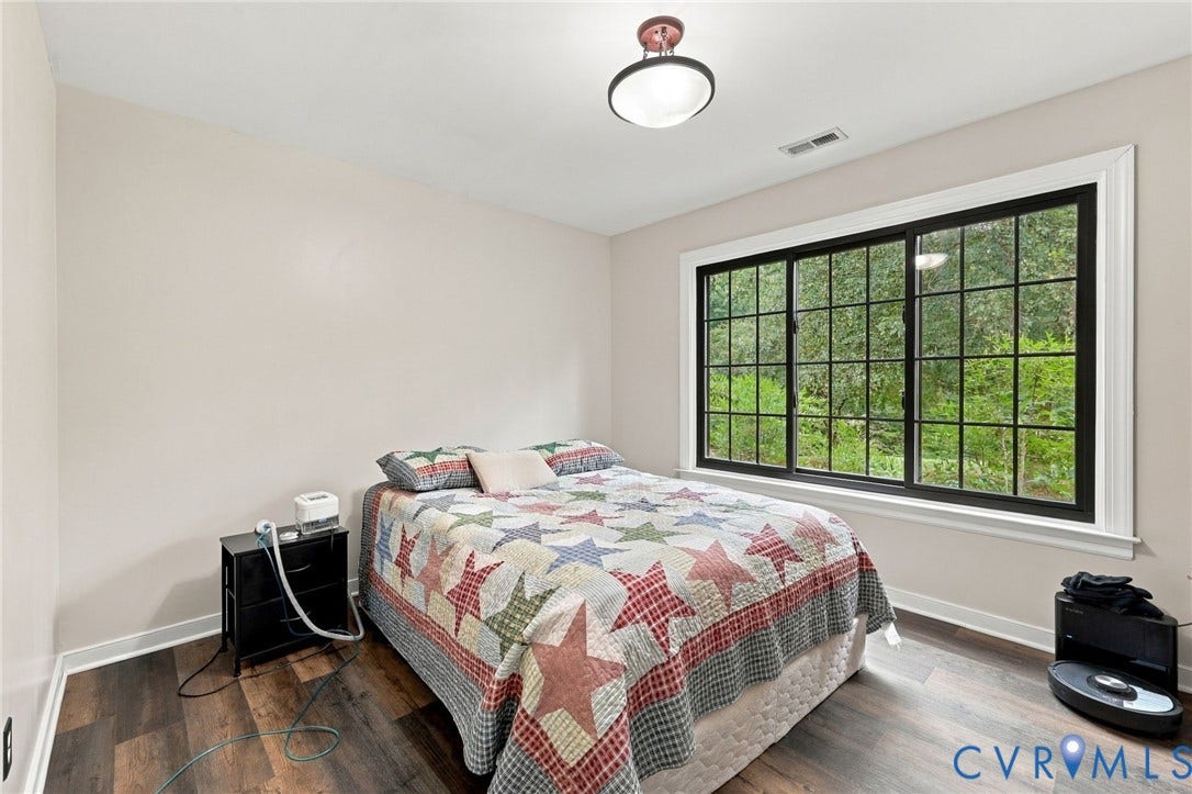 133 Ford Road, Bumpass, VA 23024 Wood-finish flooring, a contemporary semi-flush mount light fixture, and a large window with black grilles