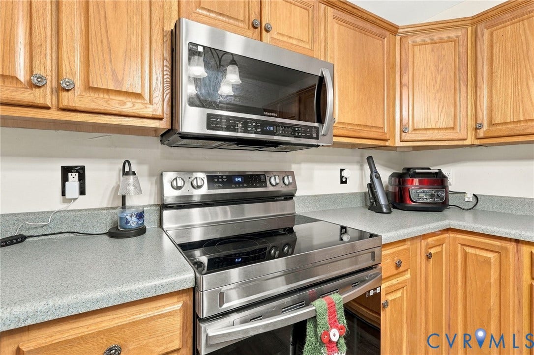 133 Ford Road, Bumpass, VA 23024 Kitchen featuring wood cabinetry, stainless steel microwave, stainless steel range with a smooth cooktop, and light-toned countertops