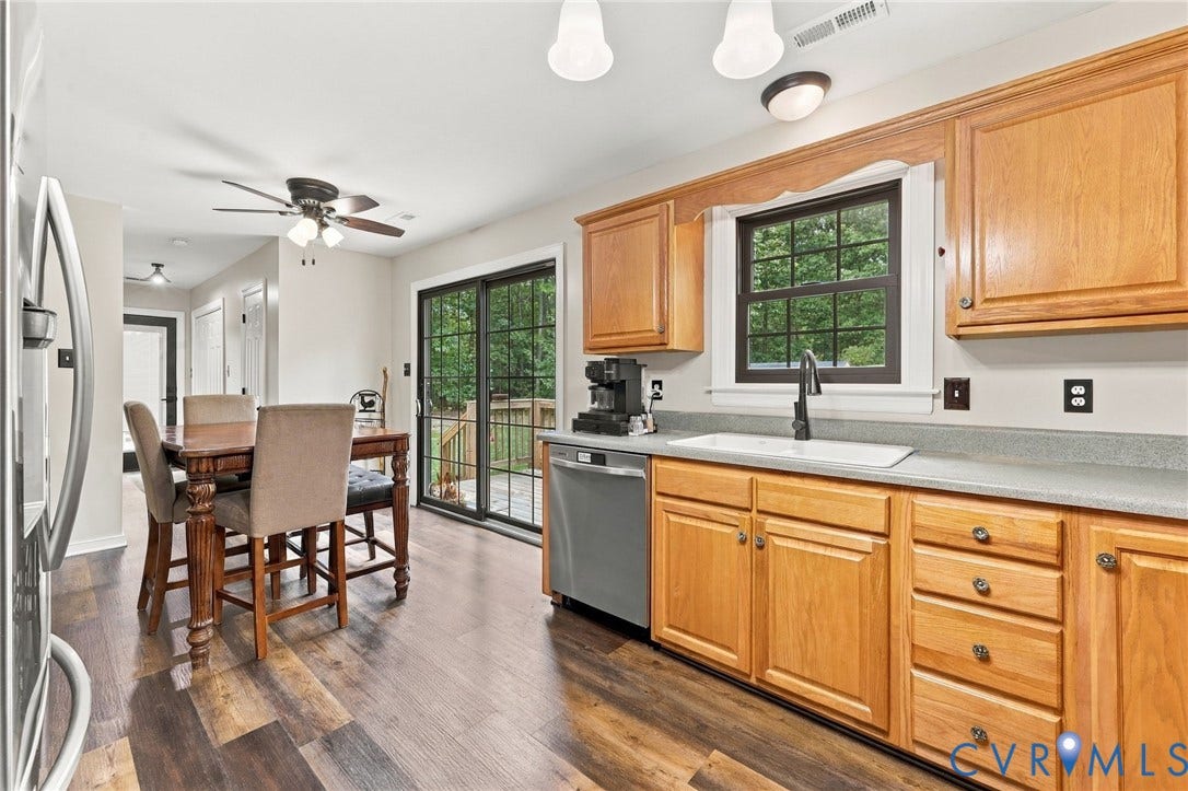 133 Ford Road, Bumpass, VA 23024 Kitchen featuring wood-finish flooring, wood cabinetry, a built-in dishwasher, and a stainless steel sink with a black faucet