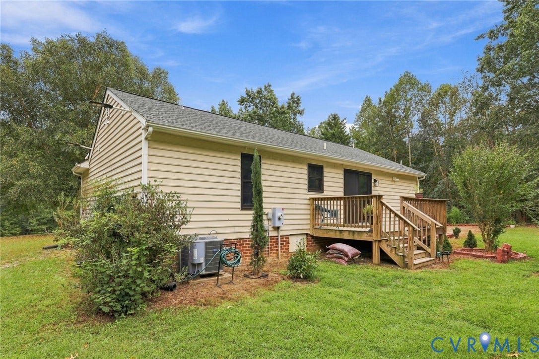 133 Ford Road, Bumpass, VA 23024 Siding exterior, wood deck, sliding glass door, mature trees, and landscaping