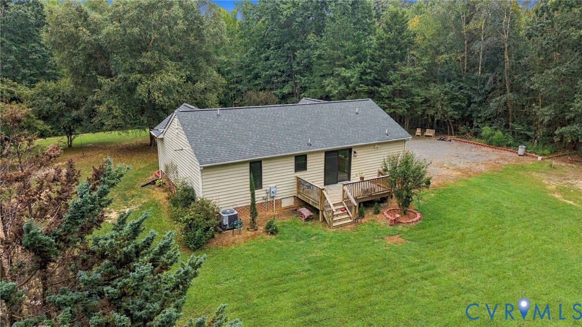 133 Ford Road, Bumpass, VA 23024 Vinyl siding exterior with a dark shingle roof, a wood-finish deck, and a sliding glass door