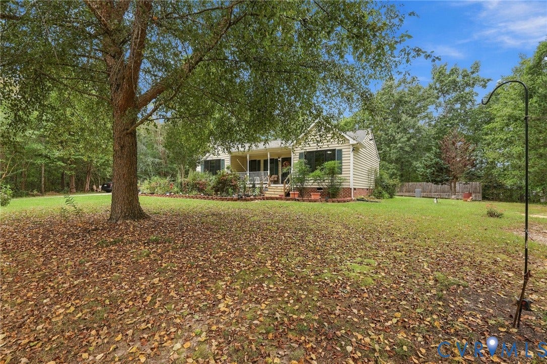 133 Ford Road, Bumpass, VA 23024 Siding exterior with a covered front porch, brick foundation, and a lush green lawn