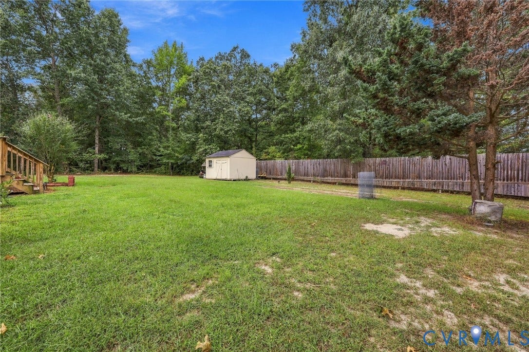 133 Ford Road, Bumpass, VA 23024 Expansive green lawn with a wood privacy fence and mature trees