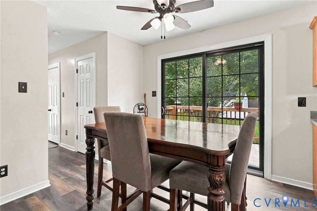 133 Ford Road, Bumpass, VA 23024 Dining area with dark wood table and upholstered chairs opening to a expansive glass sliding door system