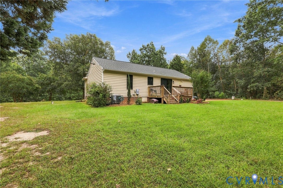 133 Ford Road, Bumpass, VA 23024 Expansive grass lawn with mature trees and a rear wood deck
