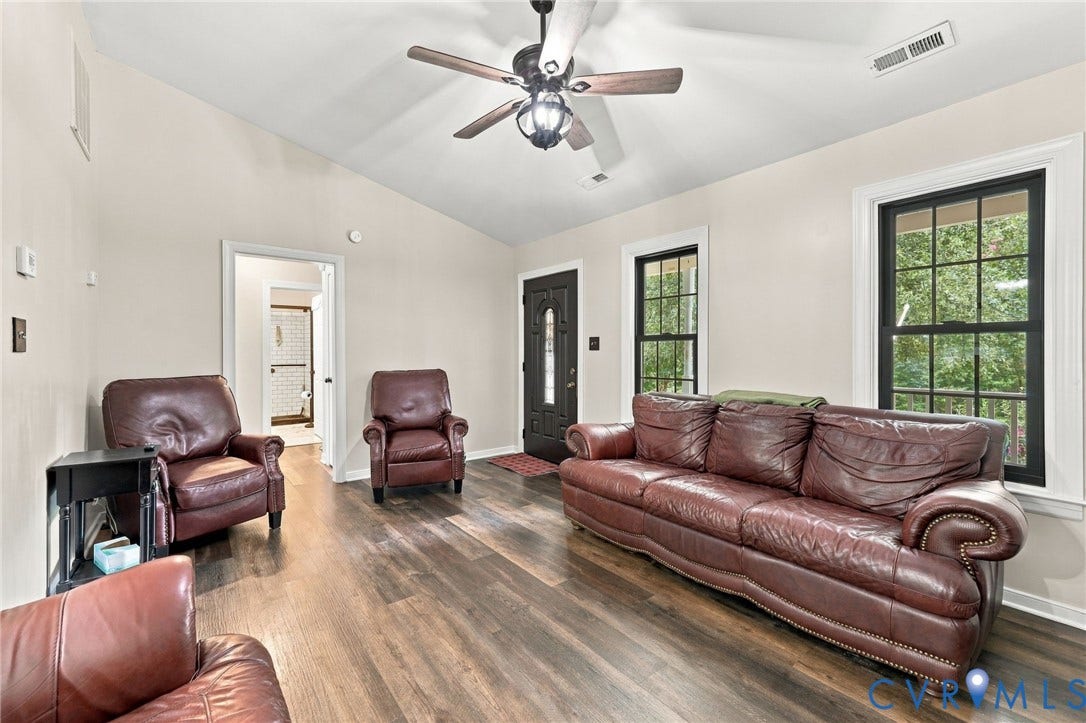 133 Ford Road, Bumpass, VA 23024 Wood-finish flooring, vaulted ceiling, black-framed windows, and a ceiling fan with light fixture