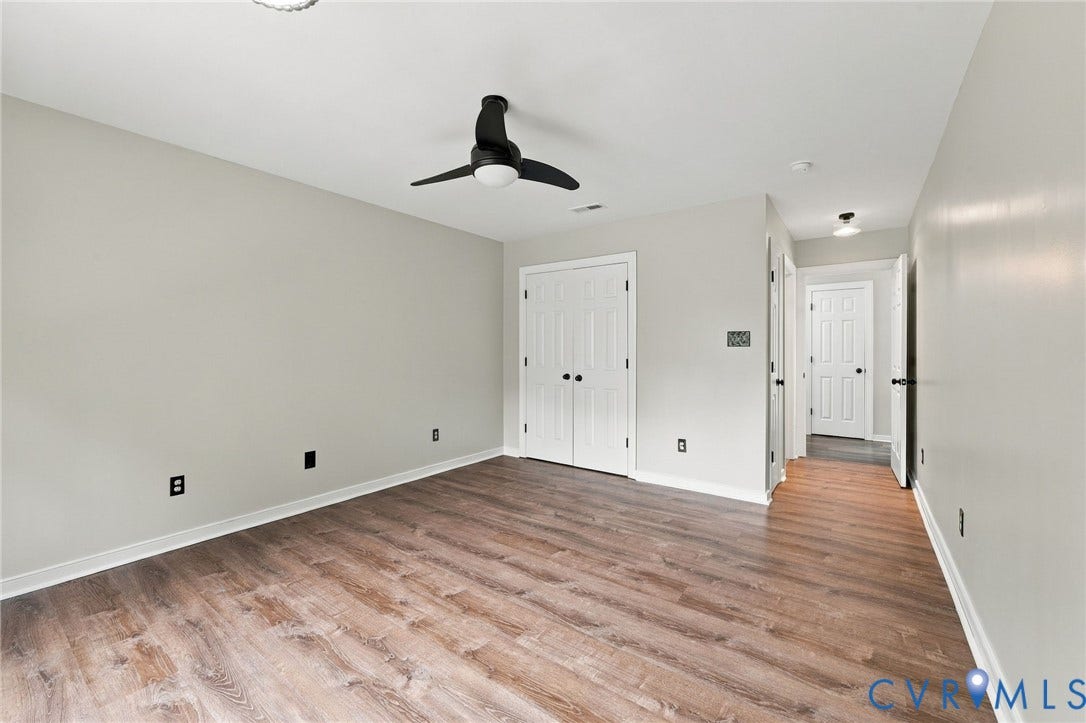 133 Ford Road, Bumpass, VA 23024 Wood-finish flooring, ceiling fan, white paneled doors, and light gray wall paint