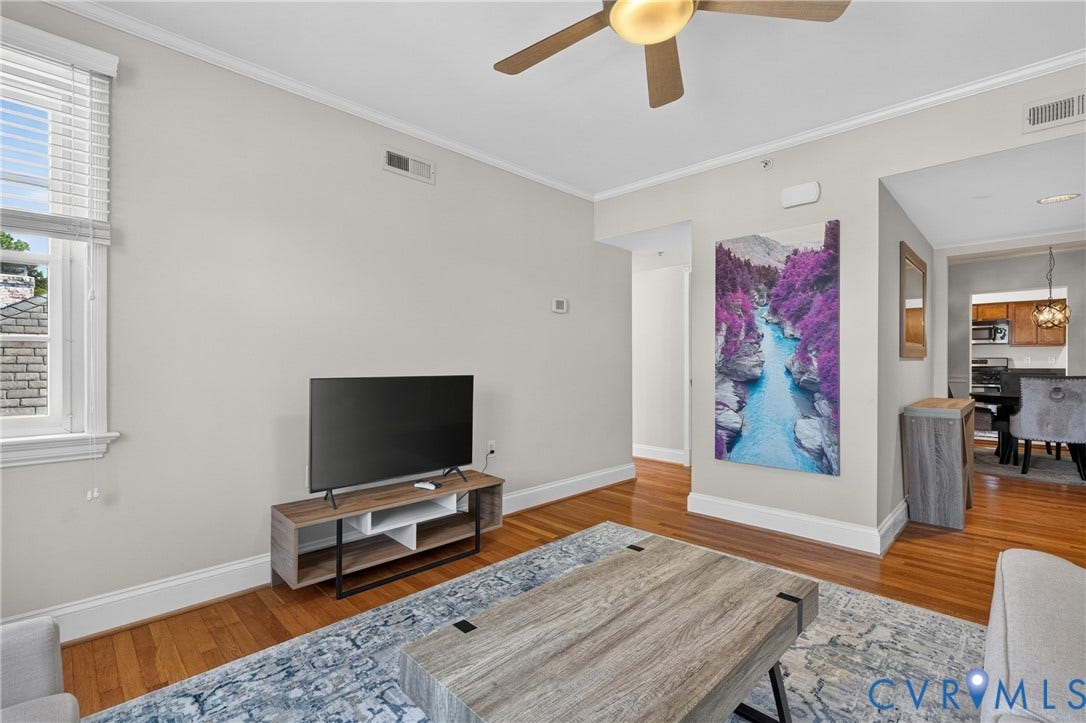 Hardwood flooring, crown molding, ceiling fan, window with blinds, and white trim