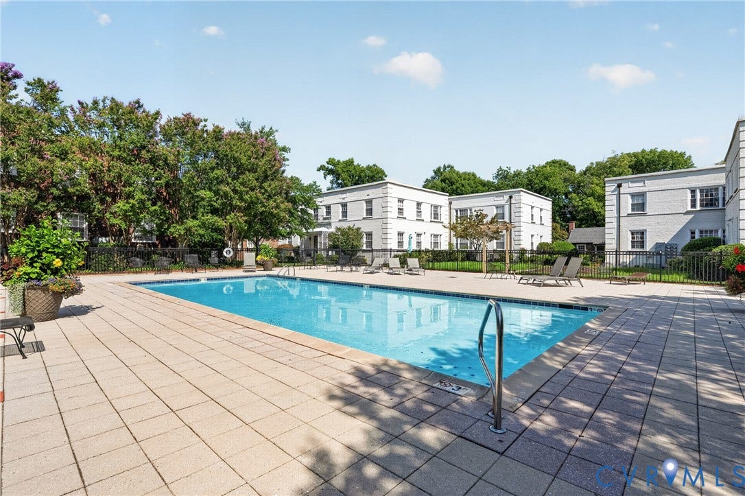 Swimming pool with a paved surround and perimeter fencing