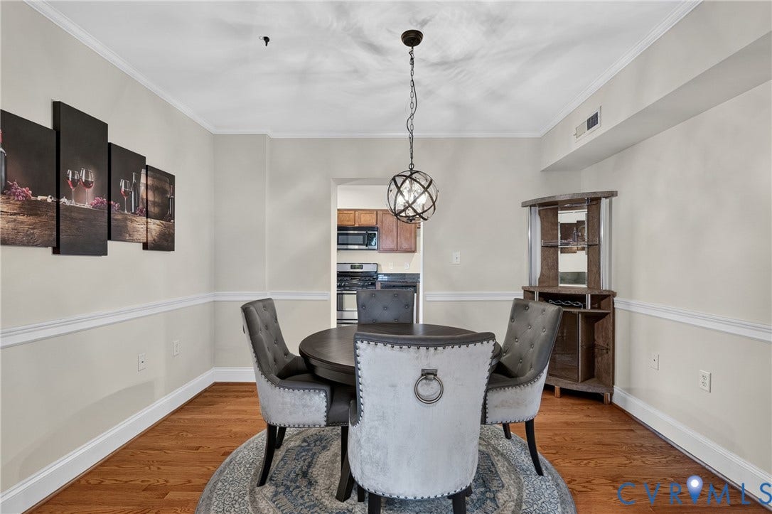 Hardwood flooring, crown molding, chair rail molding, and a built-in corner bar with shelving