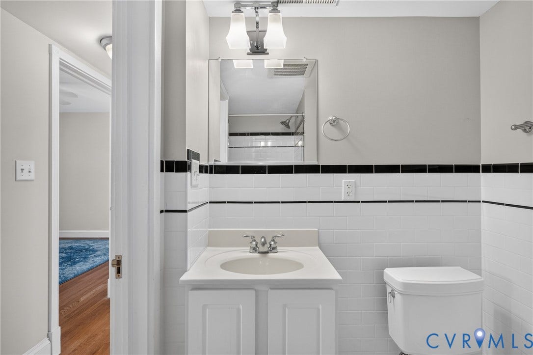 White tile wainscoting with black accent border