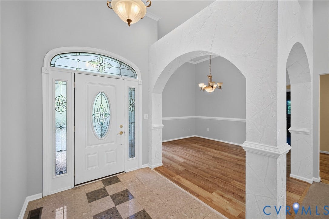 365 Hamlet Road, Manakin Sabot, VA 23103 Foyer featuring a decorative glass entry door with transom and sidelights, a checkered tile floor, and arched doorways leading to an adjacent room with wood-finish flooring