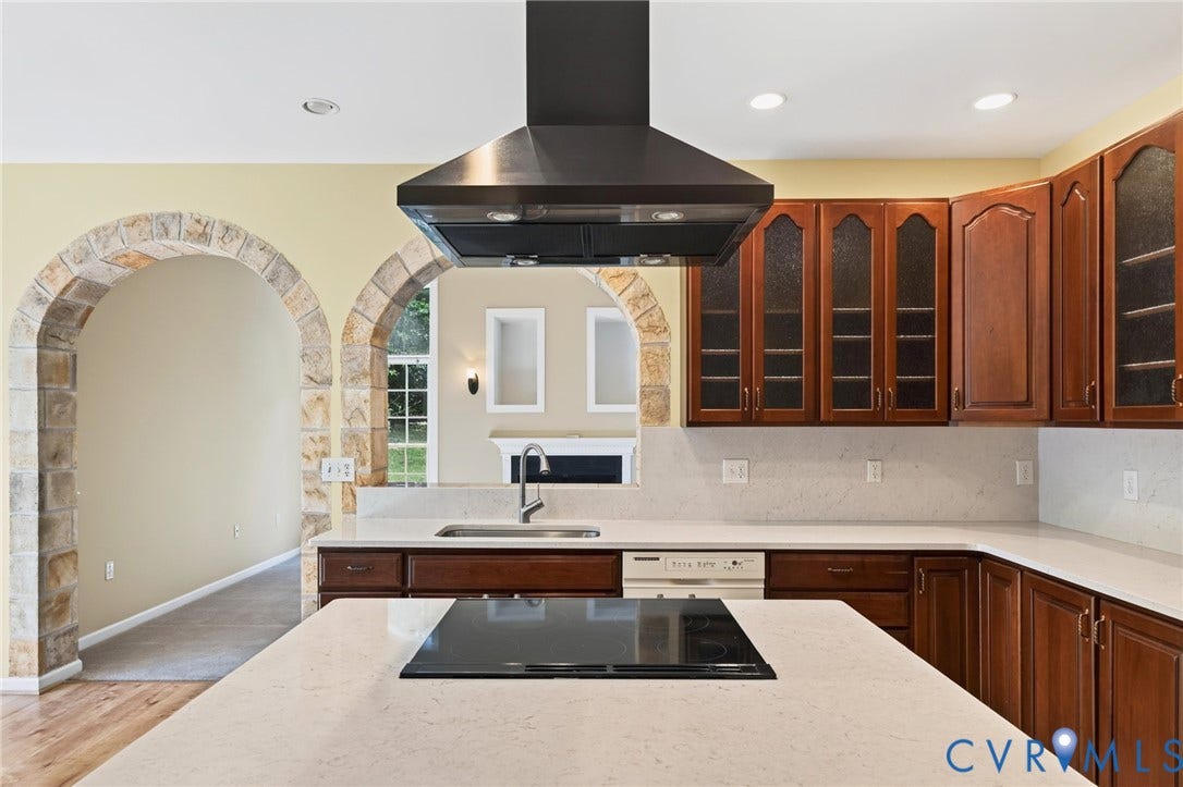 365 Hamlet Road, Manakin Sabot, VA 23103 Kitchen featuring extensive cabinetry, light-toned countertops, a built-in cooktop, and a wall-mounted range hood