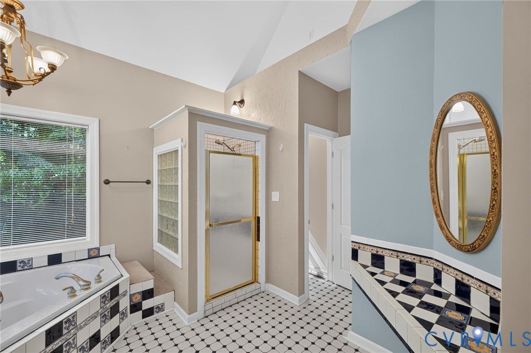 365 Hamlet Road, Manakin Sabot, VA 23103 Vaulted ceiling with an integrated chandelier, corner soaking tub with decorative tile surround, walk-in shower with glass block accent, and a tiled vanity counter