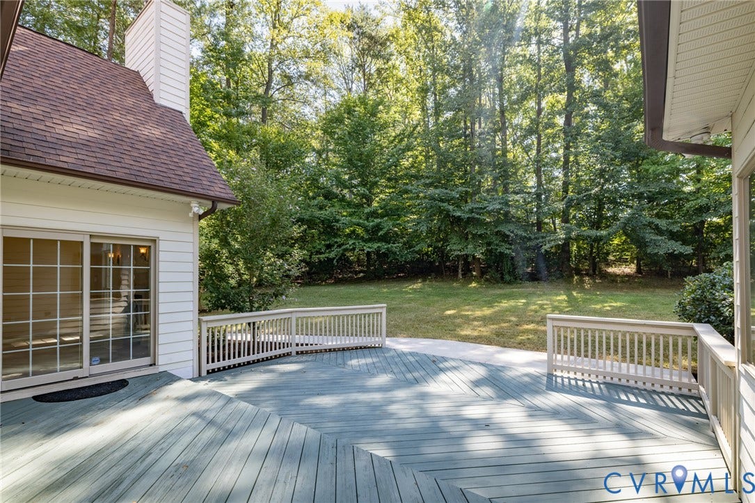 365 Hamlet Road, Manakin Sabot, VA 23103 Expansive multi-level wood-finish deck with railings, large backyard featuring a manicured lawn, mature trees, and sliding glass doors