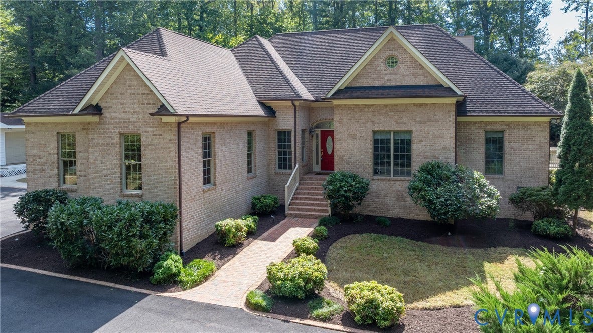 365 Hamlet Road, Manakin Sabot, VA 23103 Brick exterior with dark shingle roofing, an arched entryway, and mature landscaping
