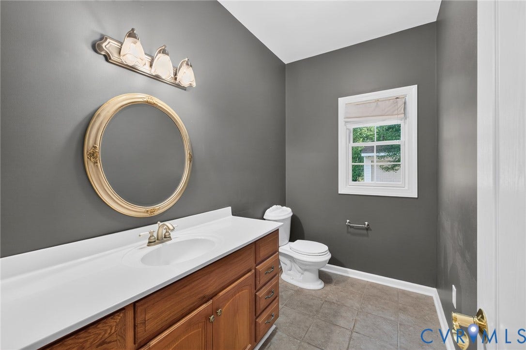365 Hamlet Road, Manakin Sabot, VA 23103 Bathroom with a solid surface countertop, an undermount sink, wood-finish cabinetry, and a window with natural light