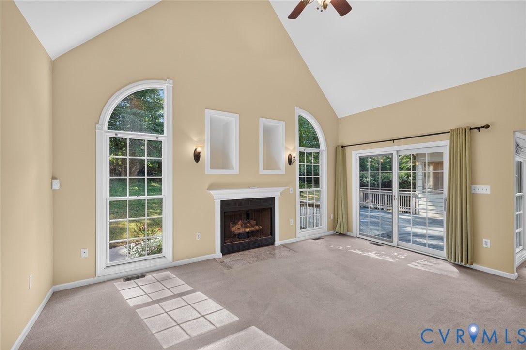 365 Hamlet Road, Manakin Sabot, VA 23103 Vaulted ceiling with a ceiling fan, fireplace with mantel, arched transom windows, built-in wall niches, and sliding glass doors to the exterior