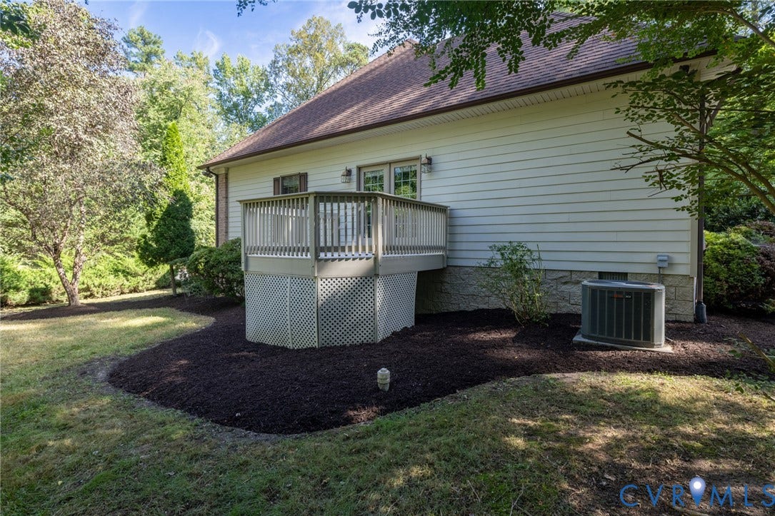 365 Hamlet Road, Manakin Sabot, VA 23103 Exterior deck with lattice skirting, double glass doors, and a manicured landscape with dark mulch