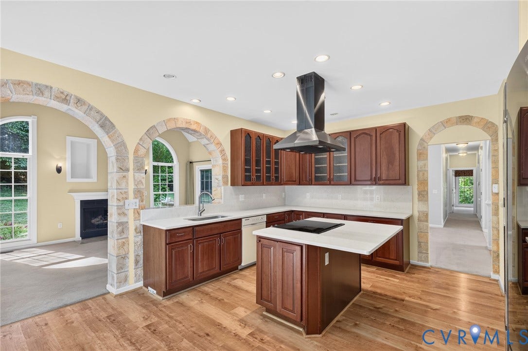 365 Hamlet Road, Manakin Sabot, VA 23103 Kitchen featuring wood-finish flooring, stone-clad arched doorways, recessed lighting, a kitchen island with a cooktop, and rich wood cabinetry