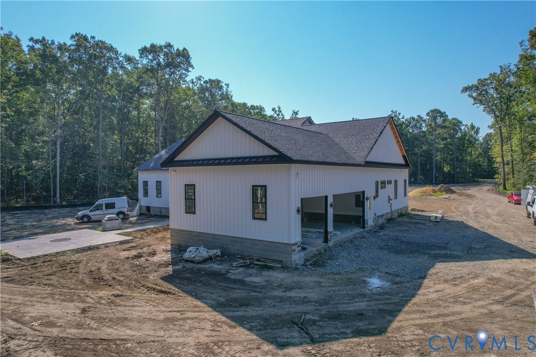 13216 Bradley Bridge Road, Chester, VA 23831 New construction property featuring white vertical siding, black-framed windows, a black shingle roof, and an attached two-car garage