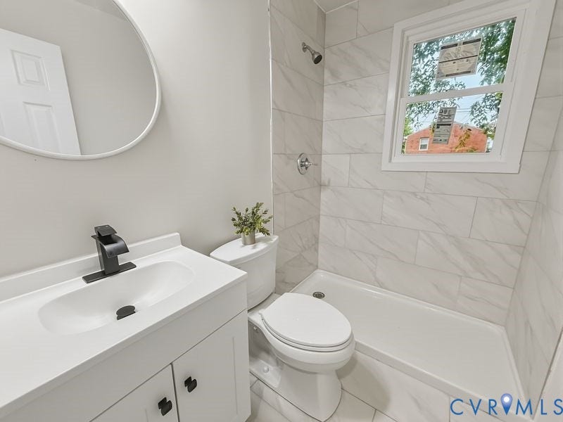 White vanity with a rectangular integrated sink and matte black faucet