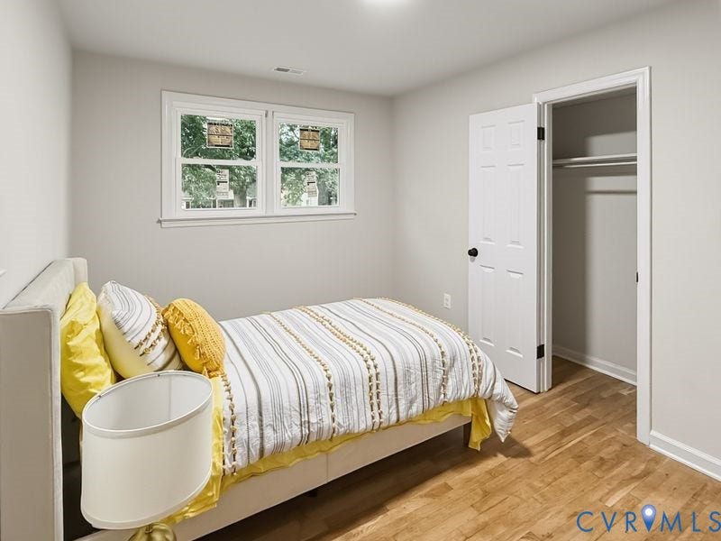 Wood-finish flooring, white trim, recessed lighting, and a built-in closet with shelving