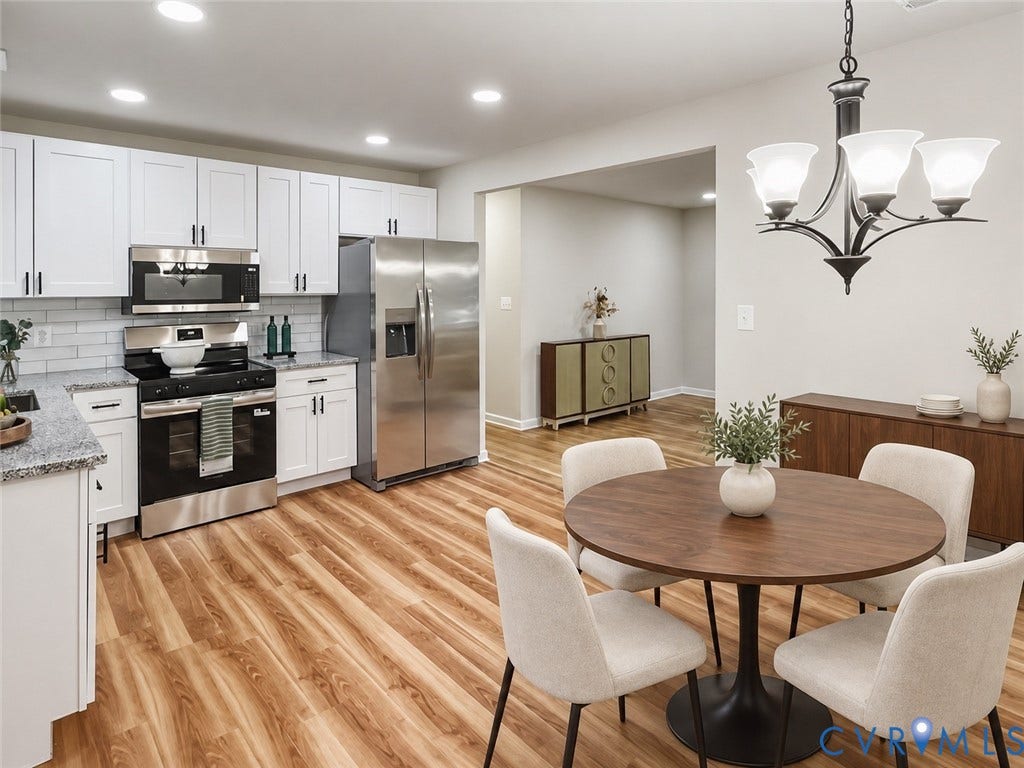 White shaker cabinetry with black hardware, stainless steel appliances, granite countertops, wood-finish flooring, and recessed lighting