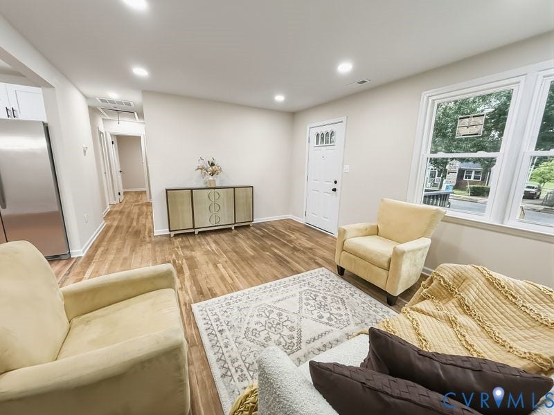 Wood-finish flooring throughout, recessed lighting, and large windows