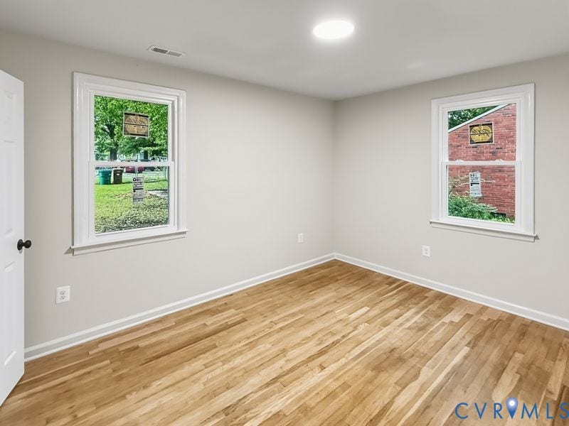 Wood-finish flooring, white trim, dual windows, and recessed ceiling lighting