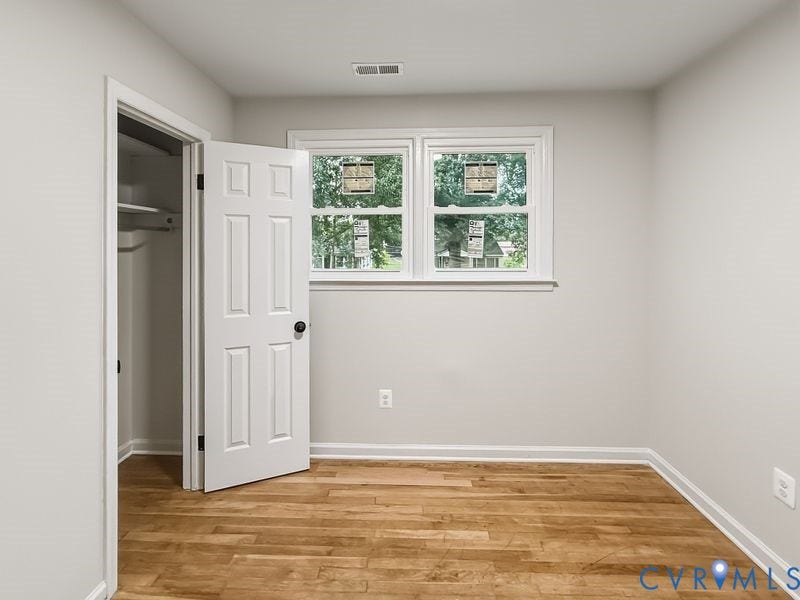 Wood-finish flooring, white trim throughout, and a double window with white casing