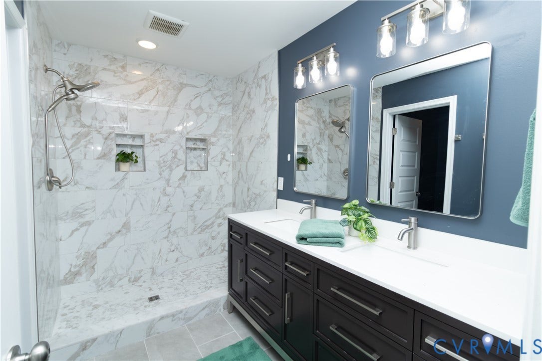 Walk-in shower with large format tile surround and integrated niches