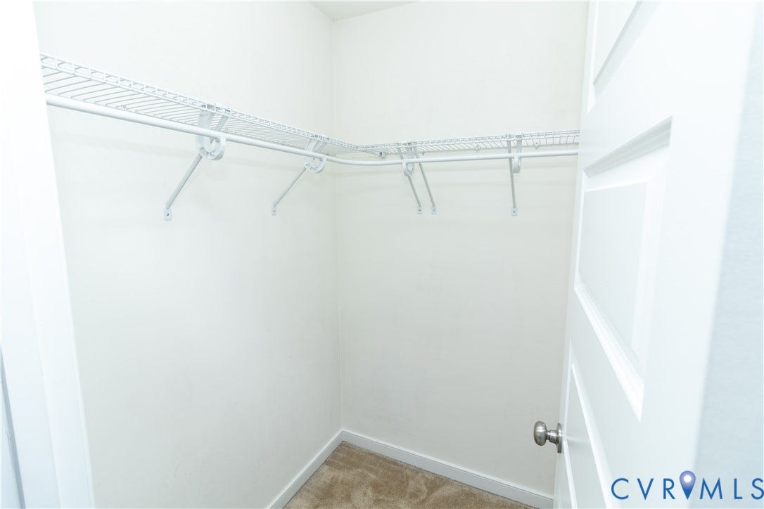 Walk-in closet with wire shelving and plush carpeting