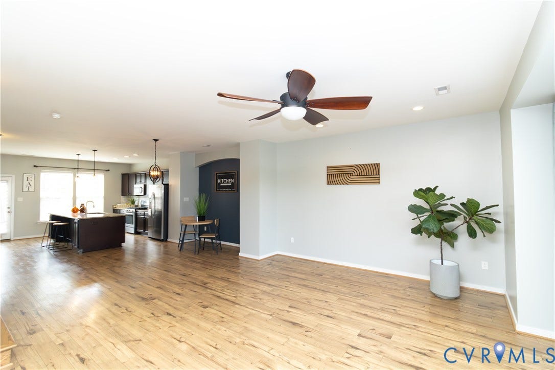Open-concept living space featuring wood-finish flooring, recessed lighting, and a ceiling fan
