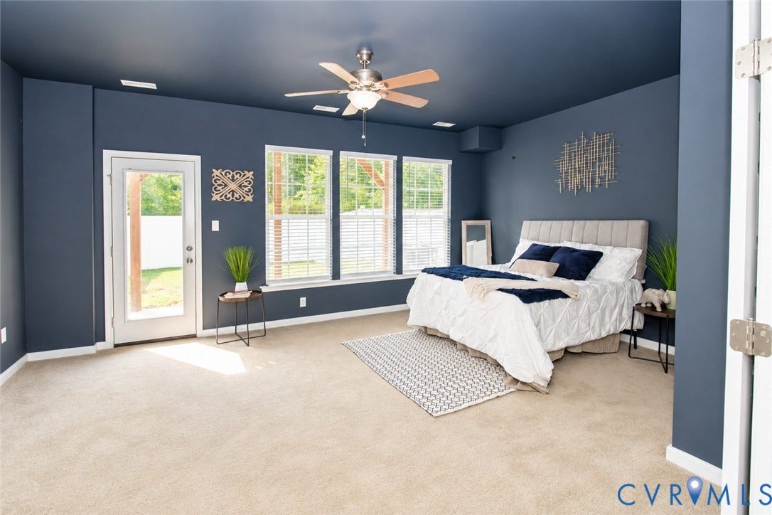 Recessed lighting, ceiling fan, three windows with blinds, glass-paned door, and carpeted flooring