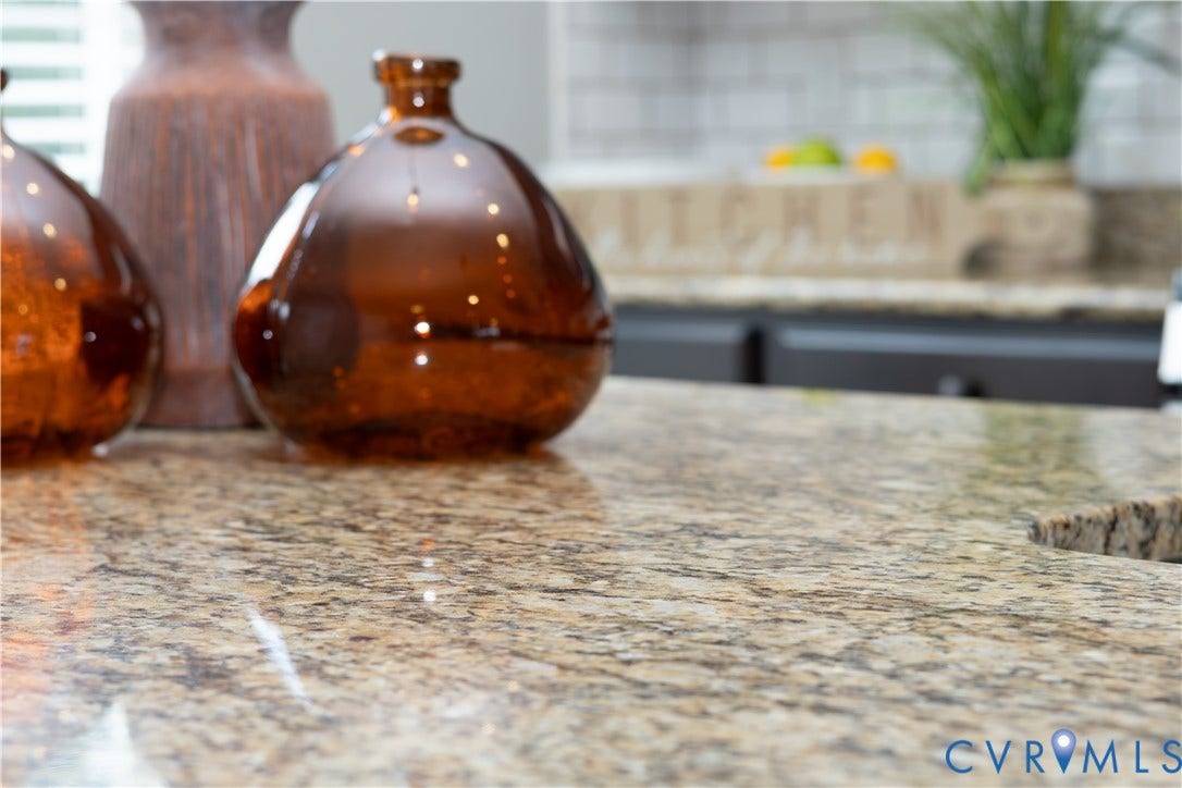 Granite-style countertop with a polished finish and a white subway tile backsplash